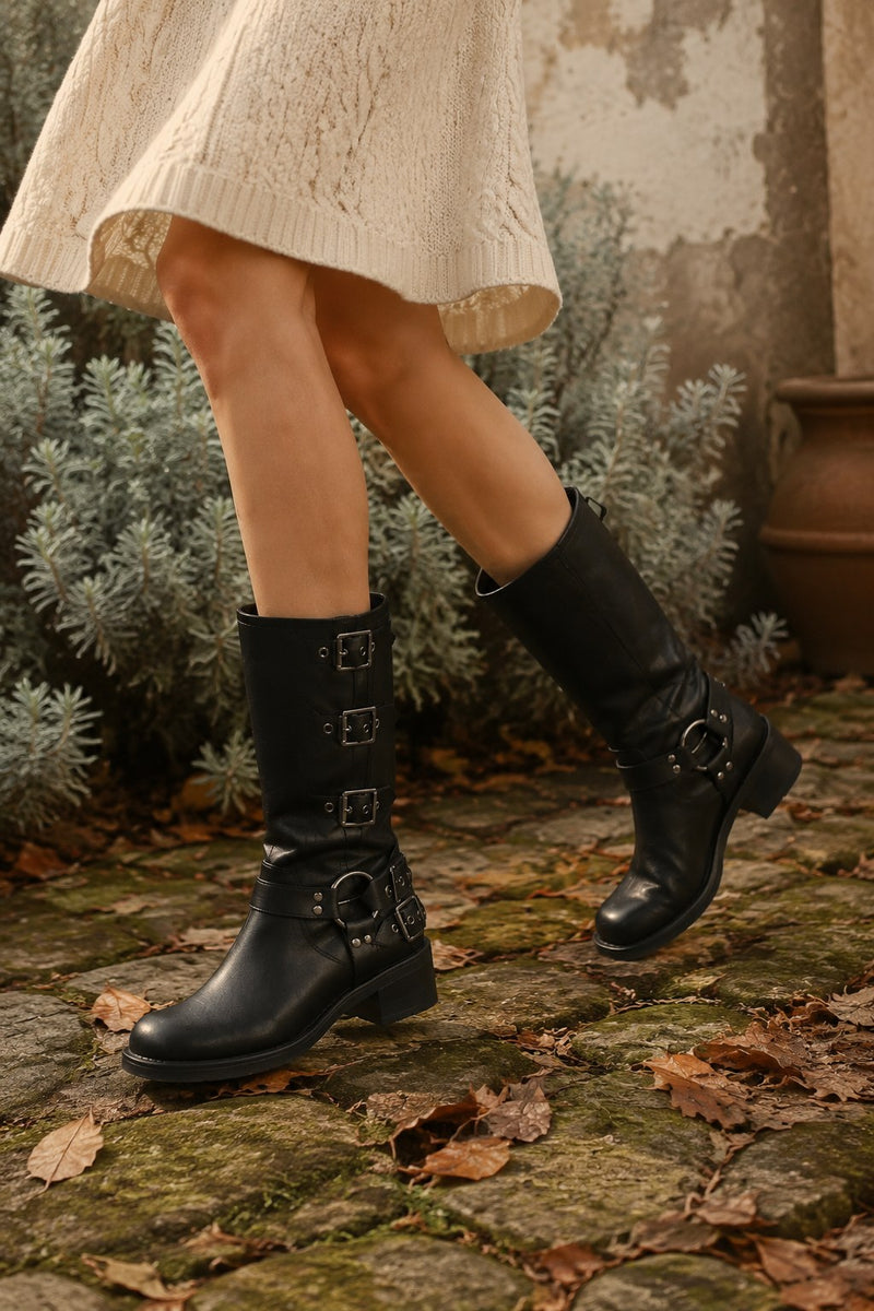 Black buckle knee-high boots on a garden path